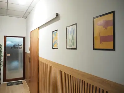 a hallway with a door and three pictures on the wall at Bed Space Hostel Khaosan in Bangkok