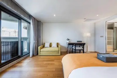 a bedroom with a bed and a desk and a window at Iconic skyline, Big apartment, Great location in Bangkok