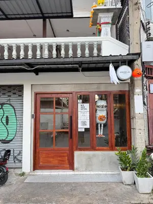 a store front with a wooden door on a building at House Ju in Bangkok
