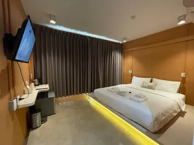a bedroom with a bed and a flat screen tv at The Palette Bangkok Hotel - Self check-in after 10 pm in Bangkok