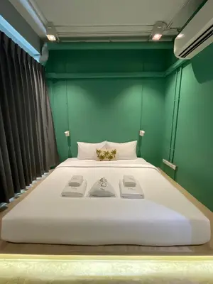 a large bed in a room with a green wall at The Palette Bangkok Hotel - Self check-in after 10 pm in Bangkok