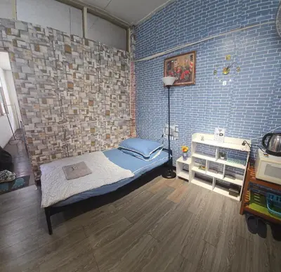 a bedroom with a bed and a brick wall at 211 Spacious studio with breezy fan full amenities with free Wi-Fi in Bangkok