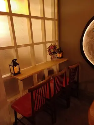 a table and chairs in a room with a window at Amsterdamned (อัมสเตอร์ดัมด์) in Bangkok