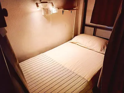 a small bedroom with a bed in a room at Amsterdamned (อัมสเตอร์ดัมด์) in Bangkok