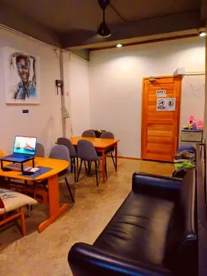 a room with a table and chairs and a couch at Amsterdamned (อัมสเตอร์ดัมด์) in Bangkok