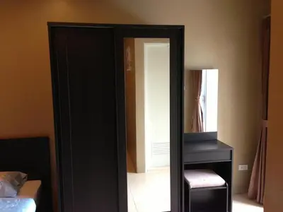 a mirror in a room with a chair and a desk at The State Apartment in Bangkok