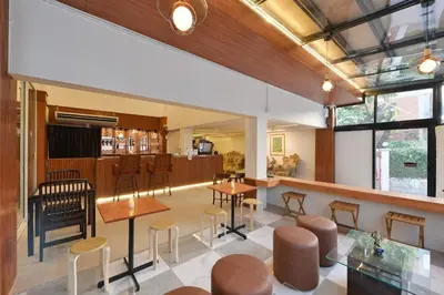 a lobby with tables and chairs and a bar at Ratchathewi Hyde Away in Pratunam