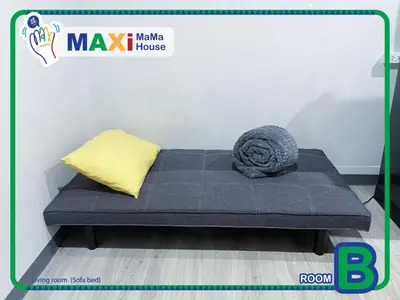 a blue couch with a yellow pillow on a floor at MAXi MaMa House in Bangkok