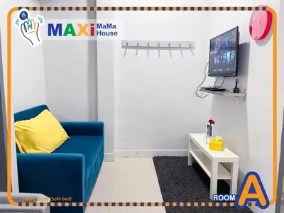 a living room with a blue couch and a tv at MAXi MaMa House in Bangkok