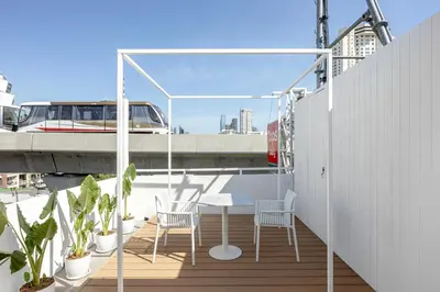 a patio with chairs and a table on a balcony at The Lair Bangkok - 3mins walk to ICON SIAM in Bangkok
