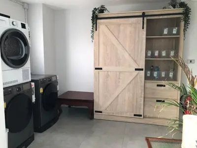 a closet with a door next to a washing machine at BaanTip​ HomStay in Bangkok