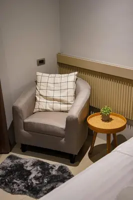 a living room with a chair and a table at BaanTip​ HomStay in Bangkok