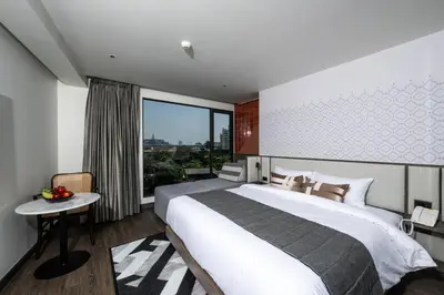 a bedroom with a large bed and a large window at WE HOTEL RIVERFRONT in Bang Su