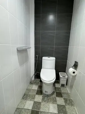 a bathroom with a white toilet and a trash can at Stay Tender in Bang Su