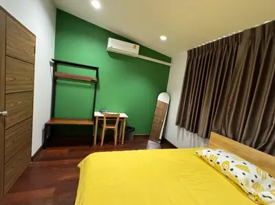 a bedroom with a yellow bed and a green wall at Stay Tender in Bang Su