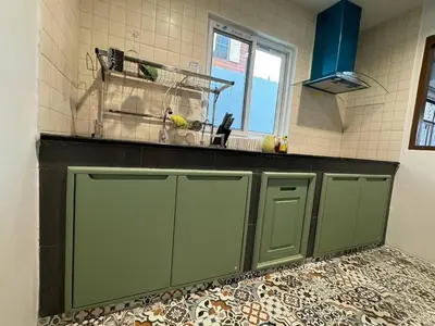 a kitchen with green cabinets and a window at Stay Tender in Bang Su