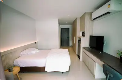 a hotel room with a bed and a television at BaanTip​ HomeStay in Amphoe Phra Khanong