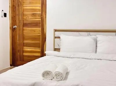 a white bed with two towels on top of it at Chubby 5 Room 4 in Ban Bang Bamru