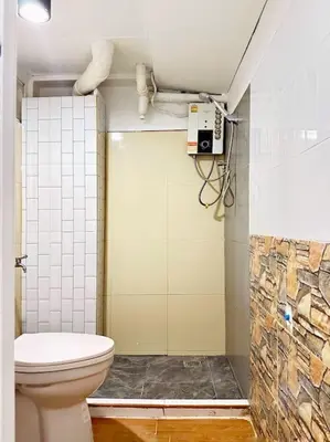 a bathroom with a toilet and a phone on the wall at Chubby 5 Room 4 in Ban Bang Bamru