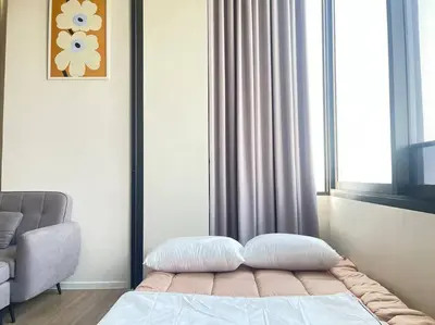 a bedroom with a bed with a window and a chair at Siamese 87 2BR \u7d20\u5764\u9038 BTS On Nut LOFT \u4e24\u623f 25 in Bangkok