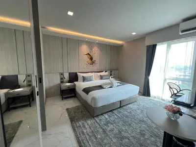 a hotel room with a bed and a desk and a room at ARNI Skye Hotel in Bangkok