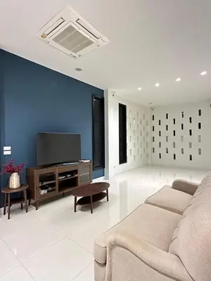 a living room with a couch and a flat screen tv at House40 MRT Ratchadaphisek in Bangkok