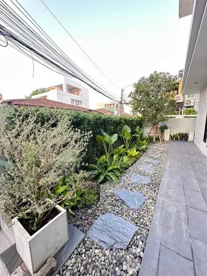 a garden with rocks and plants in front of a building at House40 MRT Ratchadaphisek in Bangkok