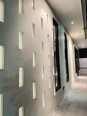 a white wall with windows in a building at House40 MRT Ratchadaphisek in Bangkok
