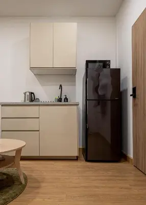 a kitchen with a black refrigerator and white cabinets at 2 Bed 2 Bath / Luxury / 1 min walk to BTS Asok in Bangkok