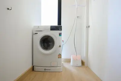 a washing machine in a room next to a door at 2 Bed 2 Bath / Luxury / 1 min walk to BTS Asok in Bangkok