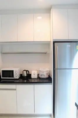 a kitchen with white cabinets and a refrigerator at Entire 3BR Townhome, Pool, Sukhumvit, BTS&MRT Asok in Bangkok