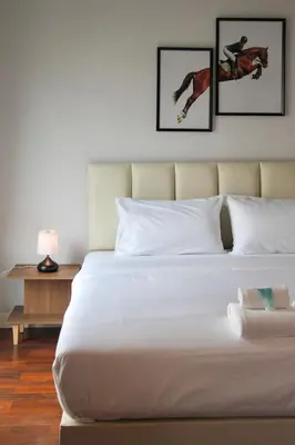 a bedroom with a large white bed with three pictures on the wall at Entire 3BR Townhome, Pool, Sukhumvit, BTS&MRT Asok in Bangkok