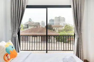 a bedroom with a bed and a large window at MIQ Ekkamai3_Pool Villa_3BR house in Bangkok