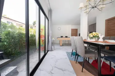 a dining room with a table and glass doors at MIQ Ekkamai3_Pool Villa_3BR house in Bangkok