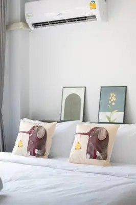 a white bed with two pillows with an elephant on it at MIQ Ekkamai3_Pool Villa_3BR house in Bangkok