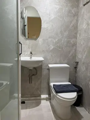 a bathroom with a toilet and a sink and a mirror at My House Guesthouse & Restaurant in Bangkok
