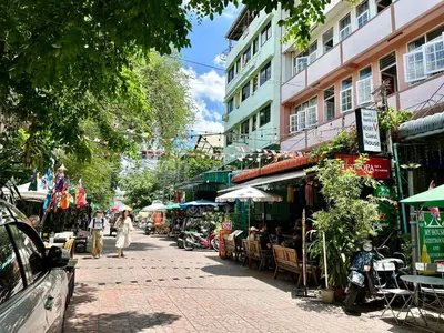 a street with an outdoor market with tables and chairs at My House Guesthouse & Restaurant in Bangkok