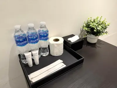 a black tray with bottles of water and toilet paper at My House Guesthouse & Restaurant in Bangkok