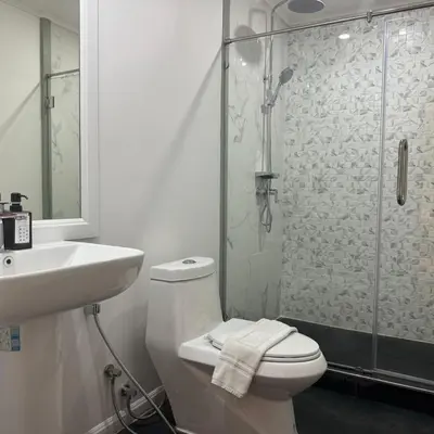 a bathroom with a shower and a toilet and a sink at O'Shea's Sukhumvit Bangkok in Khlong Toei