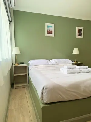 a bedroom with a large bed with white sheets and pillows at O'Shea's Sukhumvit Bangkok in Khlong Toei
