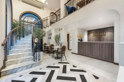 a lobby with stairs and a table and chairs at Cherie Bangkok Boutique Hotel in Bangkok