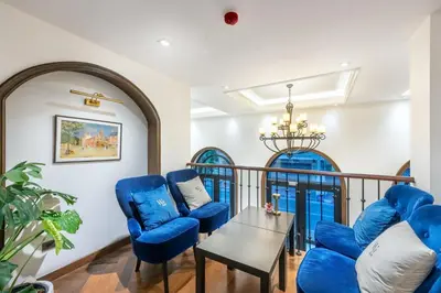 a living room with blue chairs and a table at Cherie Bangkok Boutique Hotel in Bangkok