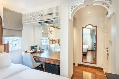 a bedroom with a bed and a desk and a mirror at Cherie Bangkok Boutique Hotel in Bangkok