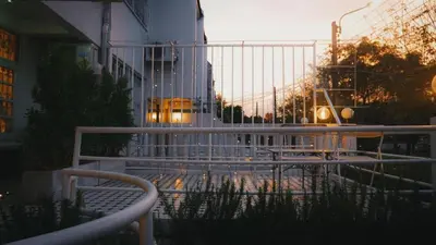 a bench in front of a building with a bus at MIDNIGHT CREPES Homecafe/Lifestyle Studio in Ban Bang Toei (1)
