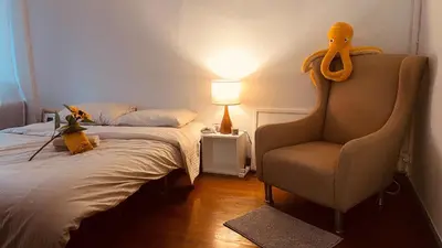 a bedroom with a bed and a chair with an octopus head on it at MIDNIGHT CREPES Homecafe/Lifestyle Studio in Ban Bang Toei (1)