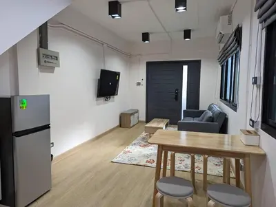a living room with a table and a refrigerator at Cloud9 Hometel - Entire House 3BR 170m to BTS Private Quiet & Comfy in Bangkok