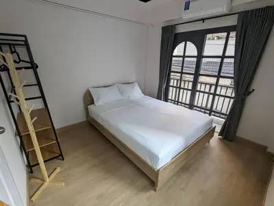 a bedroom with a bed and a ladder and a window at Cloud9 Hometel - Entire House 3BR 170m to BTS Private Quiet & Comfy in Bangkok