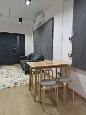 a table and chairs in a room with a couch at Cloud9 Hometel - Entire House 3BR 170m to BTS Private Quiet & Comfy in Bangkok