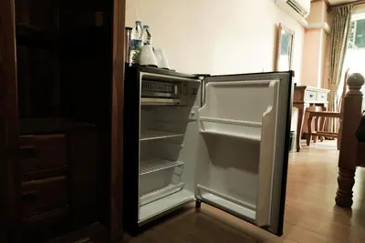an empty refrigerator with its door open in a kitchen at One Deves in Bangkok