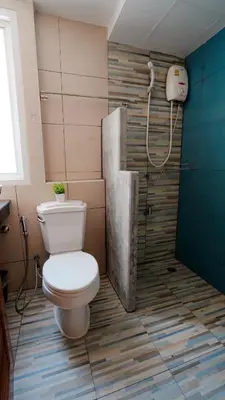 a bathroom with a toilet and a shower at One Deves in Bangkok